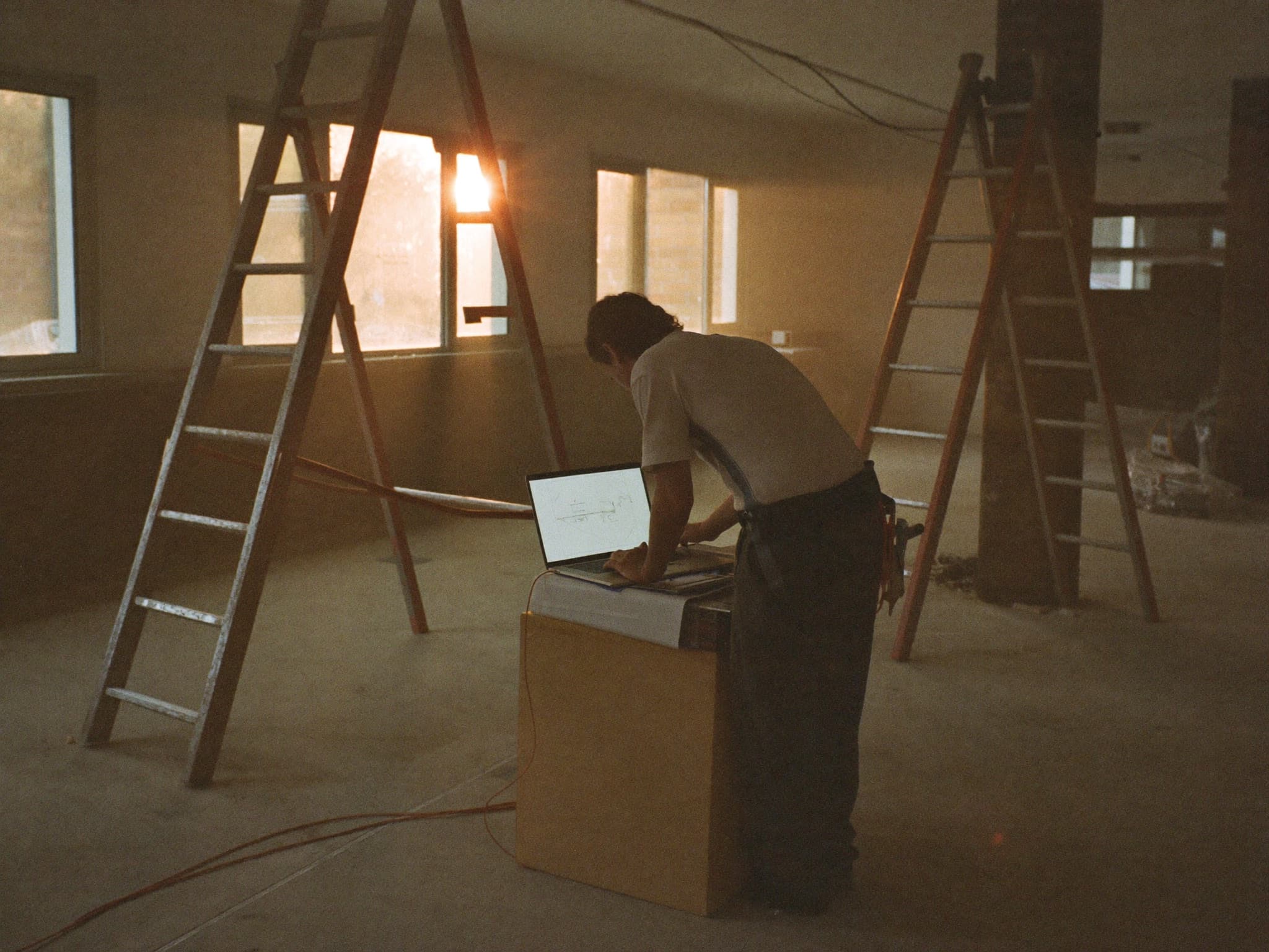 Handwerker arbeitet am Laptop auf der Baustelle